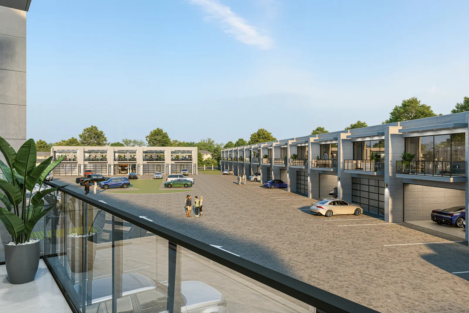 The view from a private second-floor balcony across the motor court, with glass overhead doors and balconies along the buildings opposite.